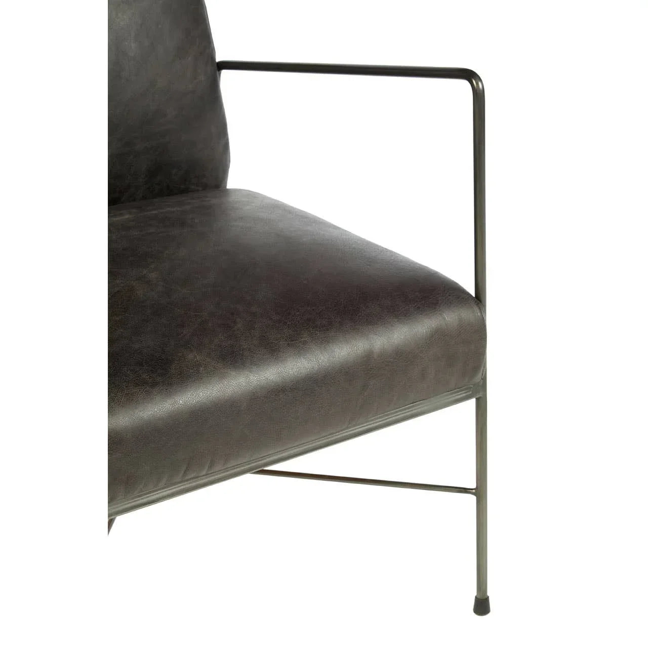Closeup of black leather accent chair seat with slim metal arm and leg