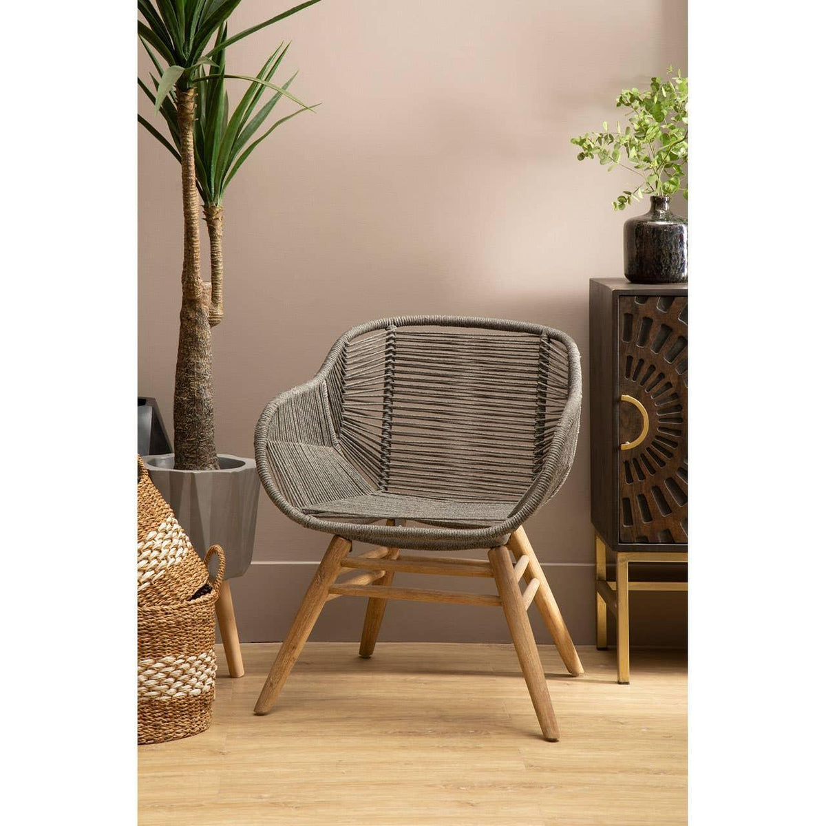 Grey rattan accent chair with wooden legs in modern living room setting