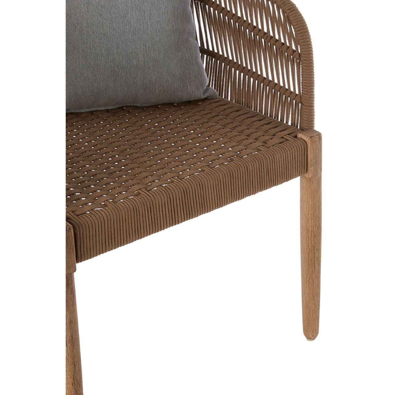 Close-up of woven rattan chair with wooden legs and grey cushion