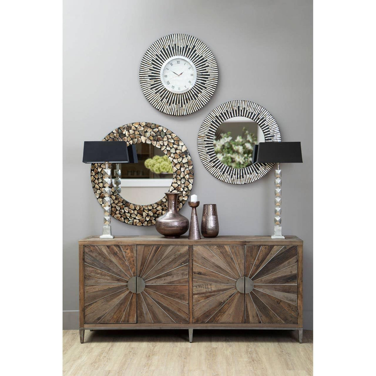 Wood sideboard with sunburst pattern, decorative mirrors, vases, and two silver lamps