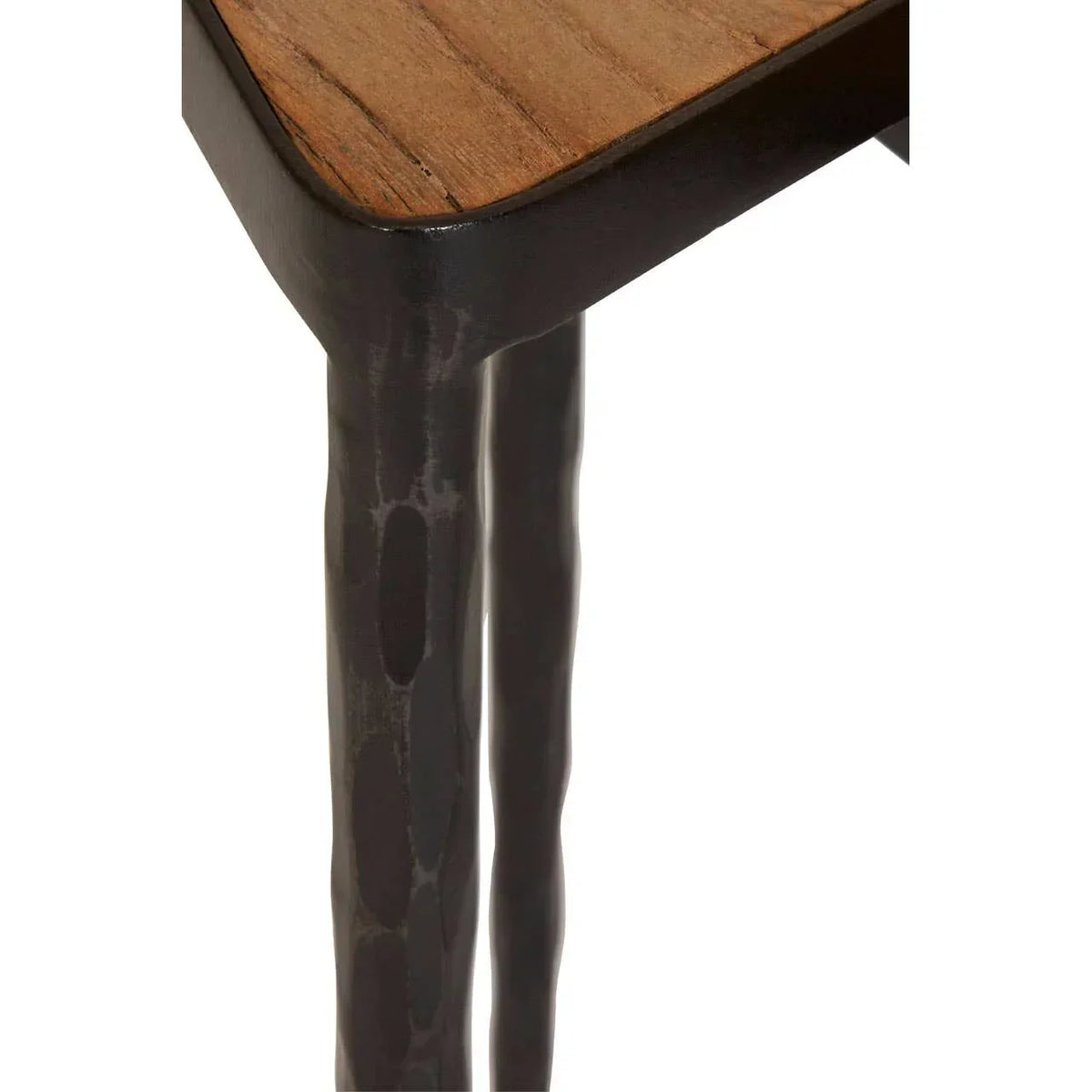 Corner view of wooden table with black metal legs and hammered texture detail