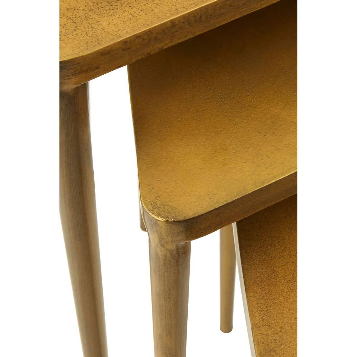 Stacked gold metal nesting tables with rounded edges and tapered legs, close view
