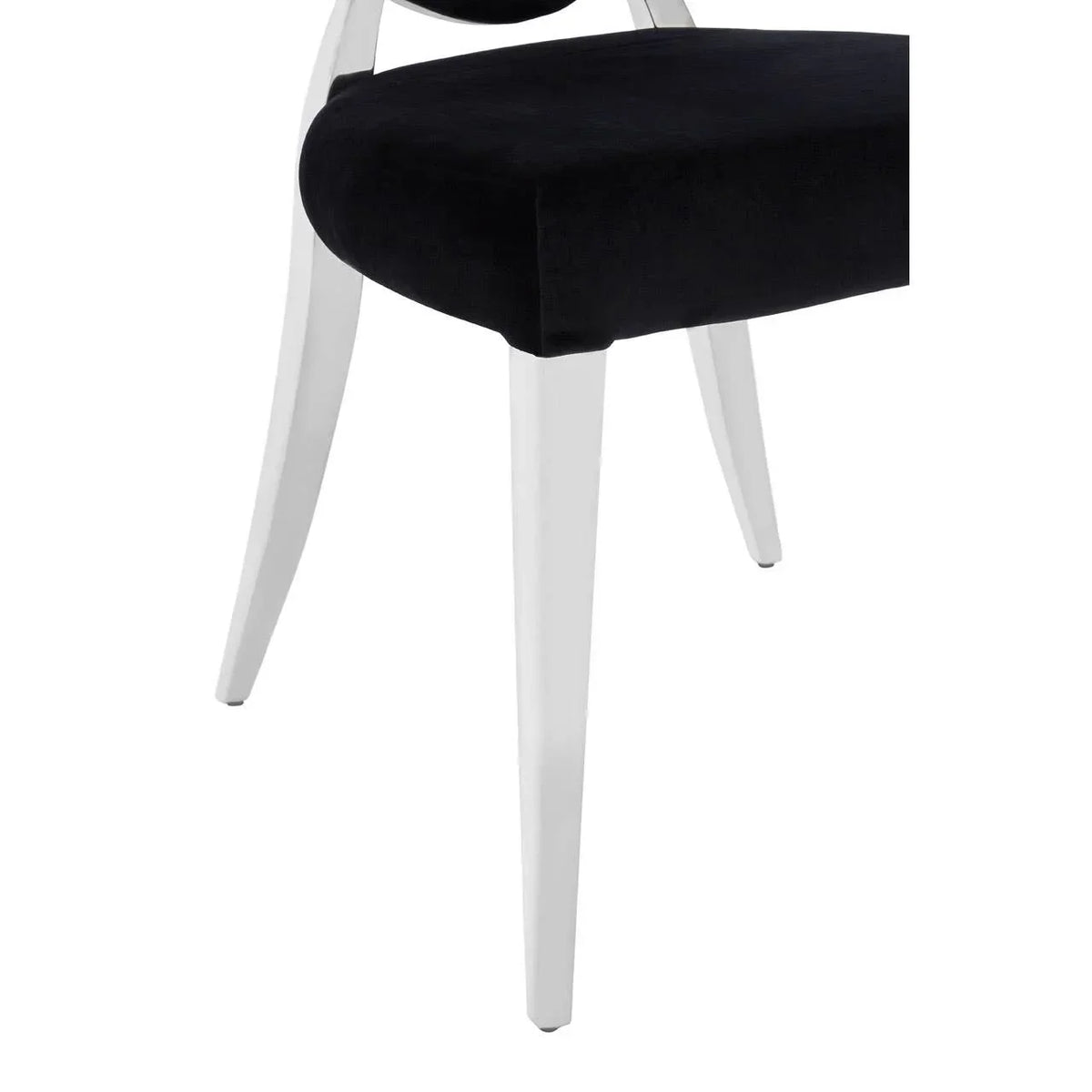 Velvet dining chair with black seat and white wooden legs, partial side view