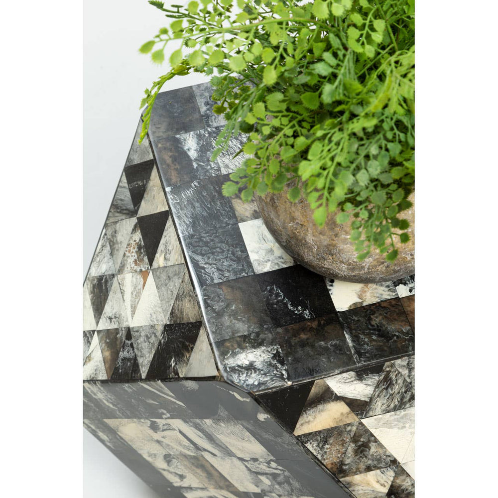 Antique green mosaic geometric hexagon side table featuring a textured surface with a mix of green, black, and cream tiles arranged in a geometric pattern. A small potted plant sits on top, adding a touch of greenery to the design. The table has a unique, angular shape that enhances its artistic appeal