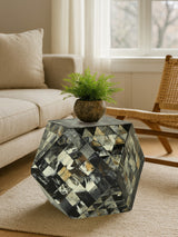 Antique green mosaic geometric hexagon side table with a reflective surface, featuring a mix of green, gold, and white tiles, placed next to a light-colored sofa and a wooden chair. A small potted plant sits atop the table, adding a touch of greenery to the scene. Natural light filters through a nearby window, illuminating the space