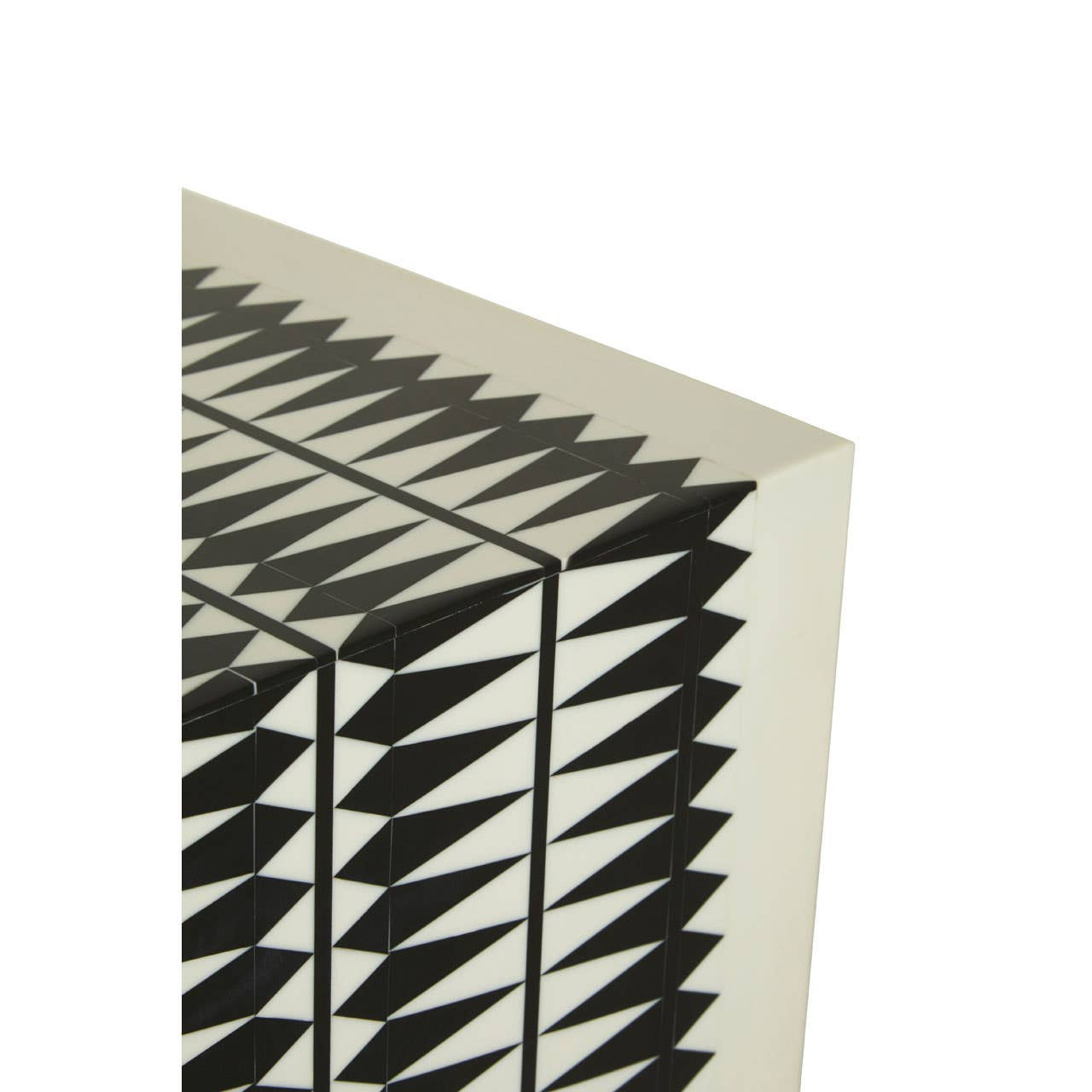A close-up view of a black and white resin table and stool featuring a geometric design with sharp, triangular patterns. The surface is smooth, showcasing a modern aesthetic suitable for contemporary home decor