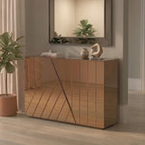 A modern console table with a tinted mirror finish, featuring a geometric design on the front. The table is positioned against a light-colored wall, with a decorative mirror above it. A potted plant is placed beside the table on the floor, enhancing the contemporary aesthetic of the room. The flooring is light wood, adding warmth to the space