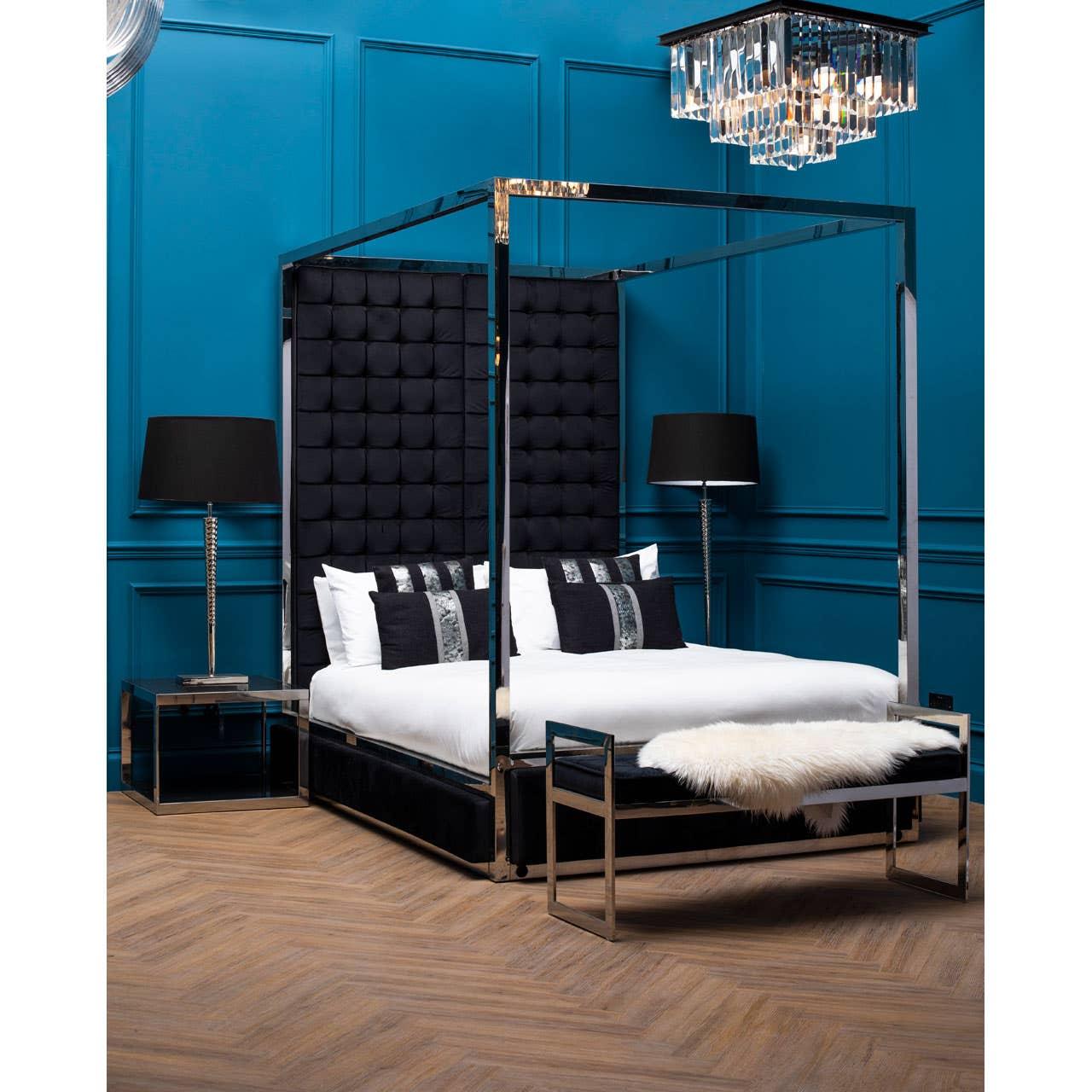Black velvet four poster bed with chrome frame, bench and bedside tables in modern bedroom