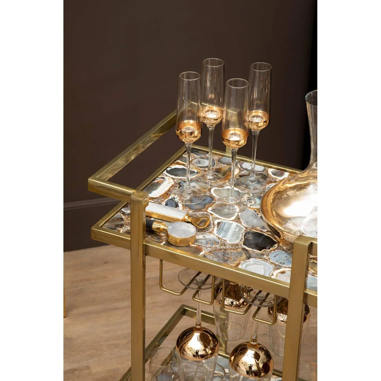 Gold bar cart with agate stone top, champagne flutes, decanter, and metallic accents