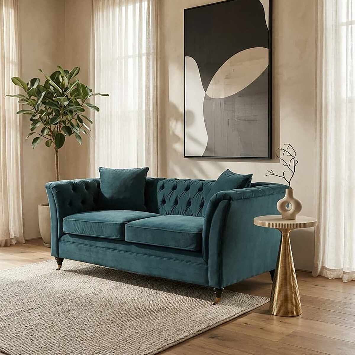 Midnight velvet two-seat sofa with tufted backrest and two matching cushions, positioned in a bright room with large windows, a potted plant in the background, and a small side table next to it. A modern piece of wall art is displayed above the sofa, and a light-colored area rug is on the floor