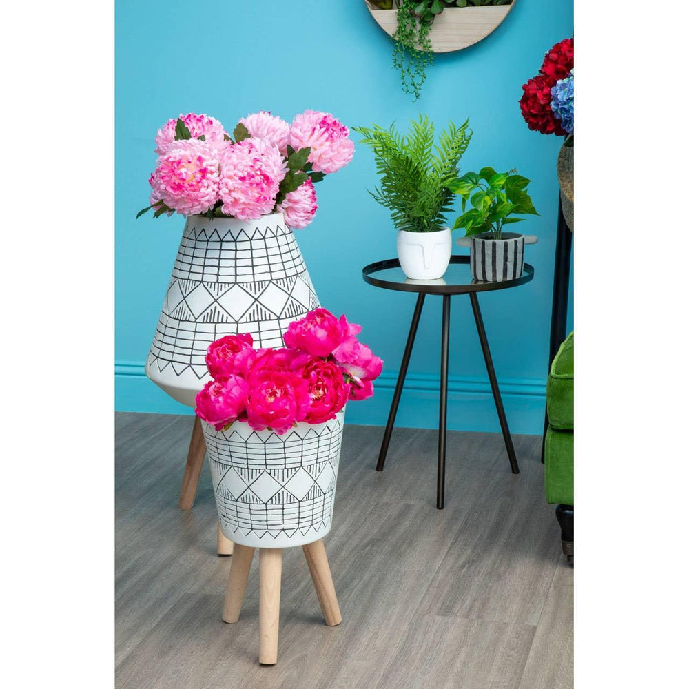 Geometric patterned plant stands with artificial flowers and potted plants in modern living room