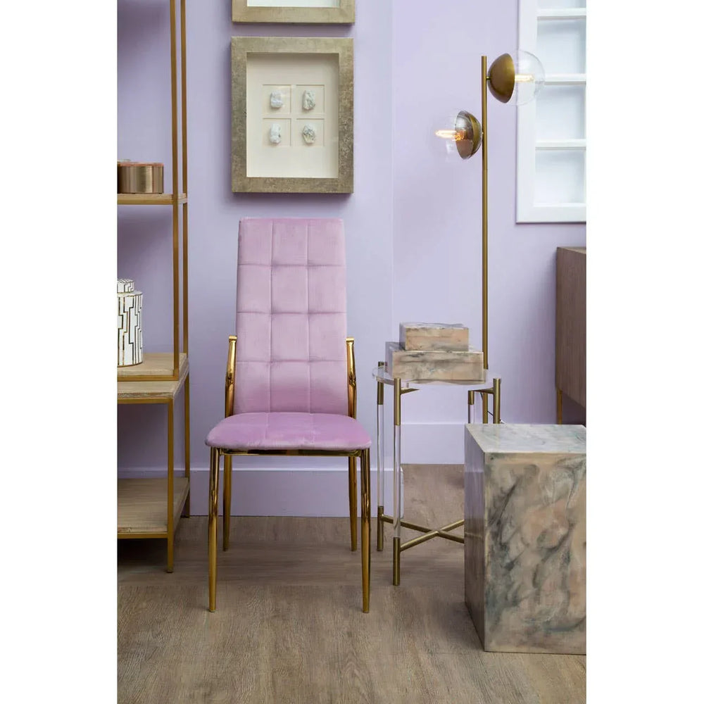 Pink velvet dining chair with gold legs positioned in a modern living room setting
