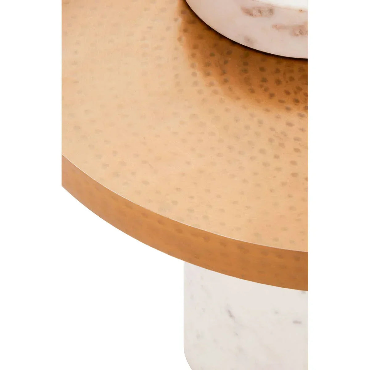 Hammered gold metal coffee table top with white marble cylindrical base close-up