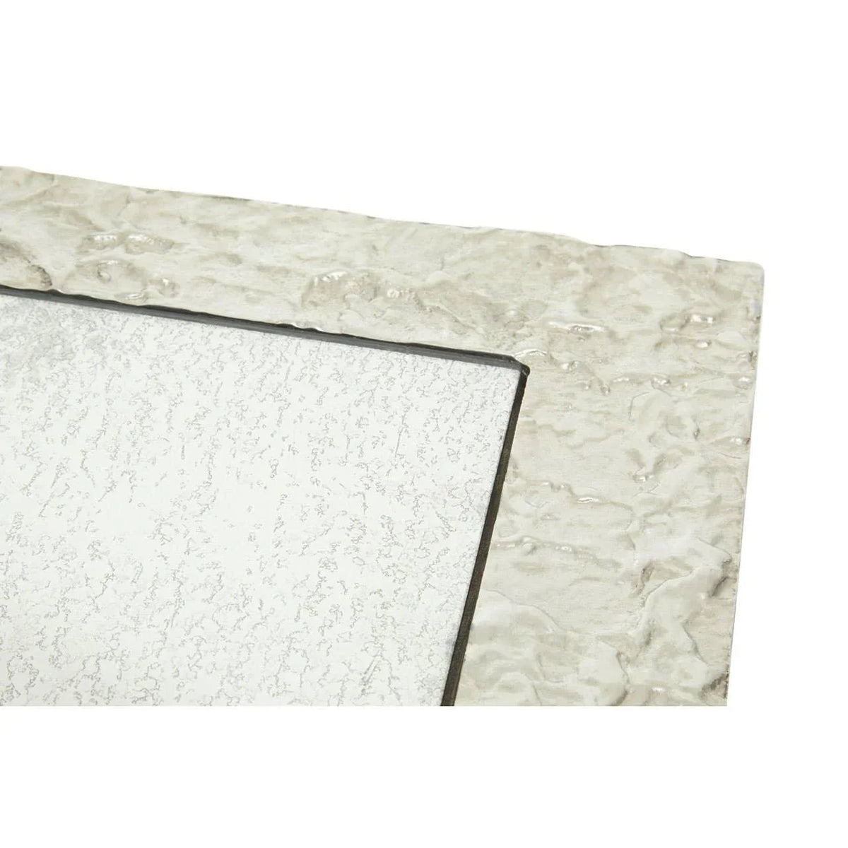 Close-up of textured silver mirror frame with metallic finish and beveled glass edge