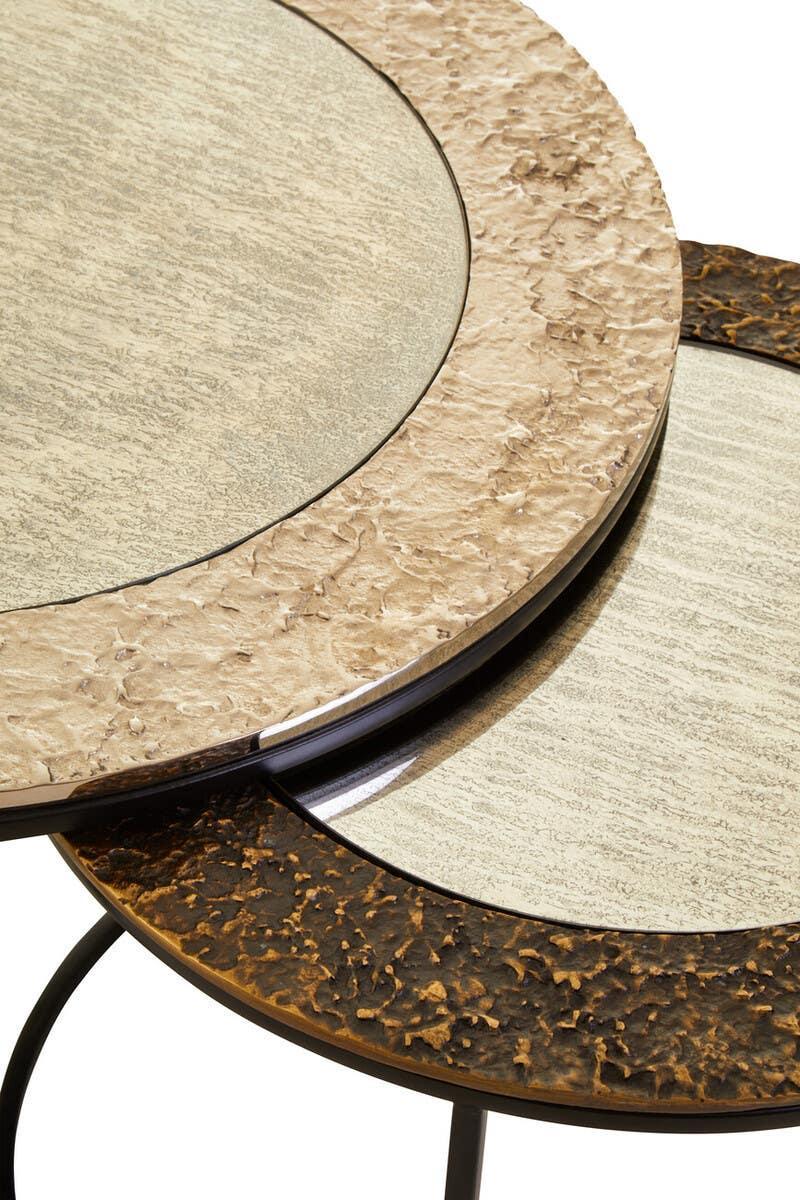 Round nesting tables with textured metal frames and glass tops in gold and bronze finish