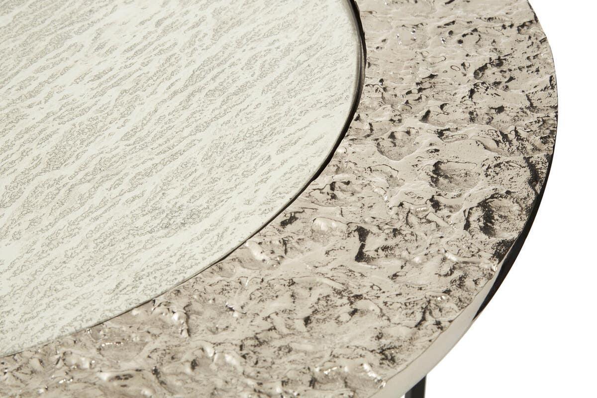 Closeup of a round metal and textured glass coffee table surface
