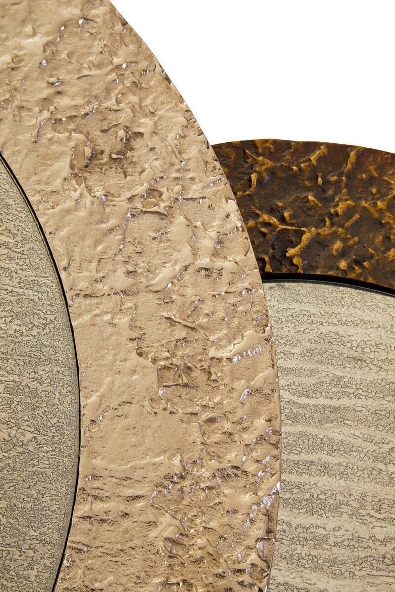 Round wall mirror with textured gold and bronze metallic frame sections