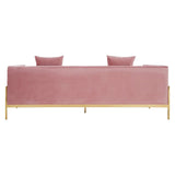 Three-seat sofa upholstered in soft pink fabric, featuring a sleek design with two matching cushions on the backrest. The sofa is supported by slender gold legs, giving it a modern and elegant appearance