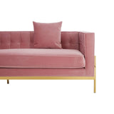 A three-seat pink sofa featuring a tufted backrest and a single matching cushion, supported by sleek gold legs. The fabric has a soft texture, adding a modern touch to the overall design
