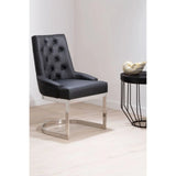 Black leather accent chair with tufted back and chrome cantilever legs beside round side table