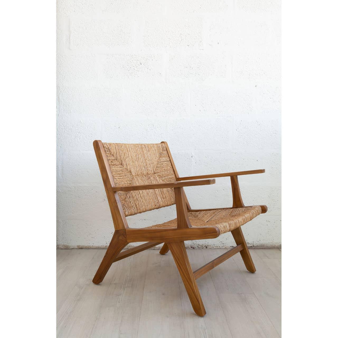Mid-century wooden lounge chair with woven rattan seat and backrest on light floor
