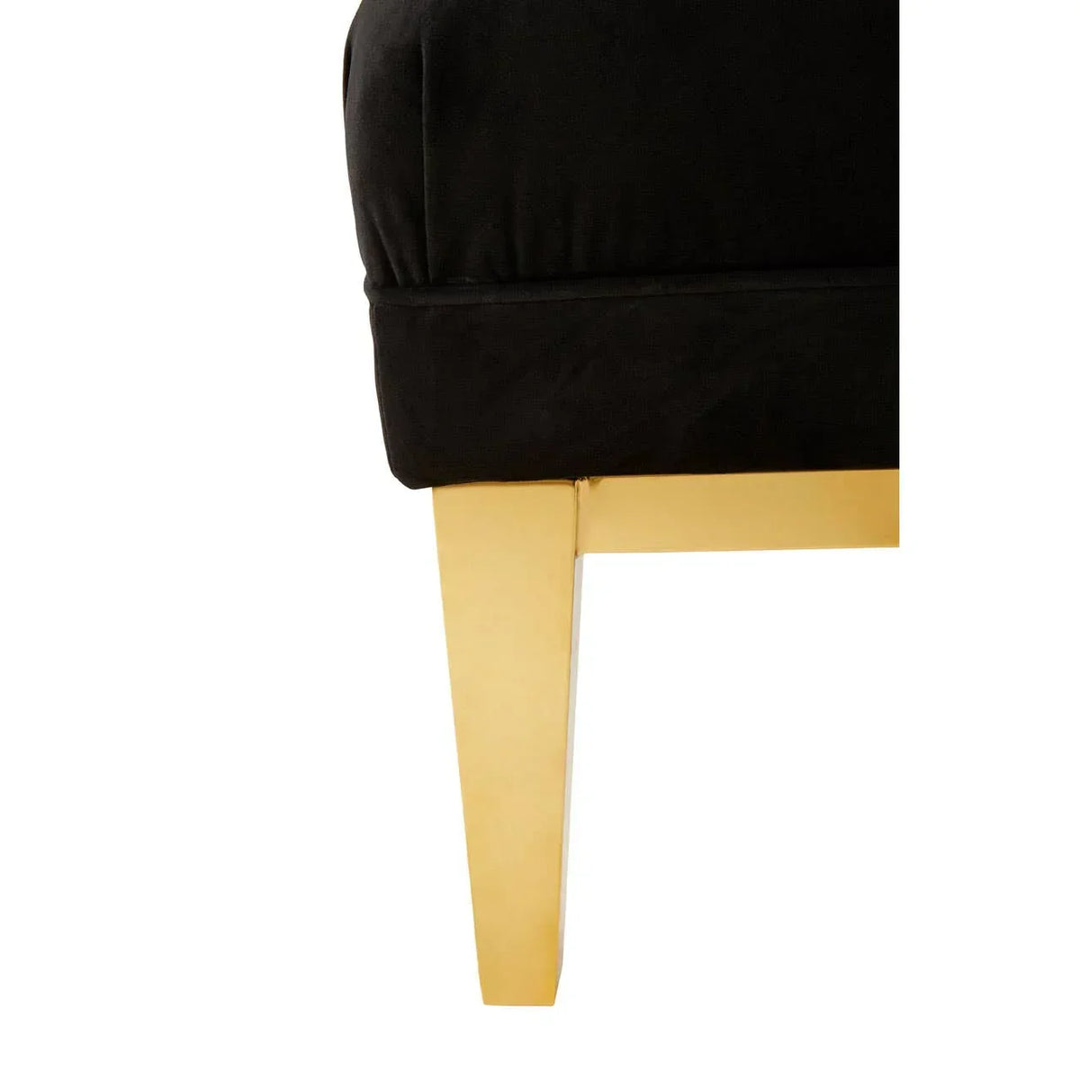 Black velvet sofa corner with gold metal leg close-up