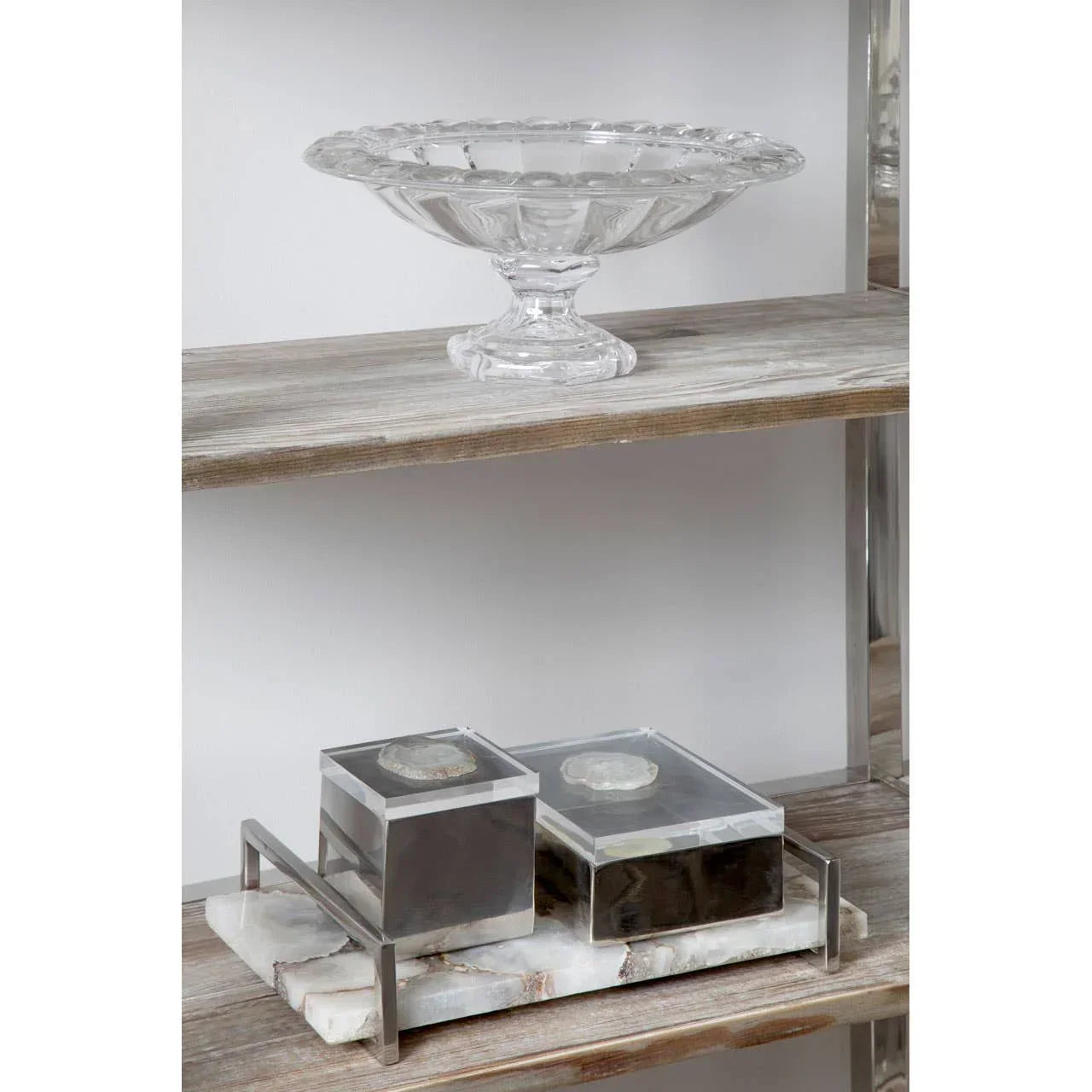 Clear glass pedestal bowl and two marble storage boxes on rustic wooden shelving unit