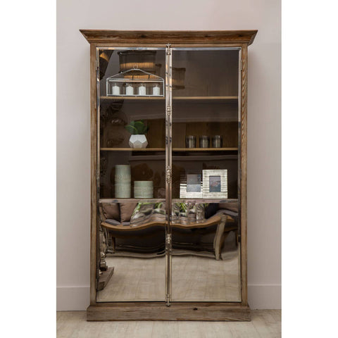 White washed pine wood cabinet with two glass doors, featuring multiple shelves displaying decorative items such as vases and picture frames. The cabinet has a rustic design with a slightly distressed finish, set against a neutral wall