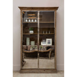 White washed pine wood cabinet with two glass doors, featuring multiple shelves displaying decorative items such as vases and picture frames. The cabinet has a rustic design with a slightly distressed finish, set against a neutral wall