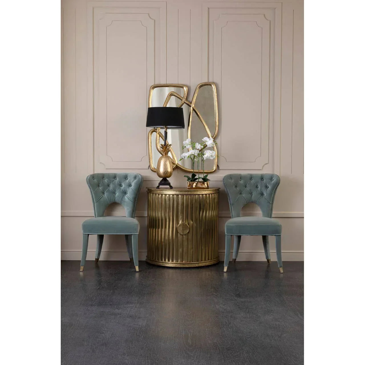 Pair of blue velvet accent chairs with gold sideboard and decorative mirror in modern room