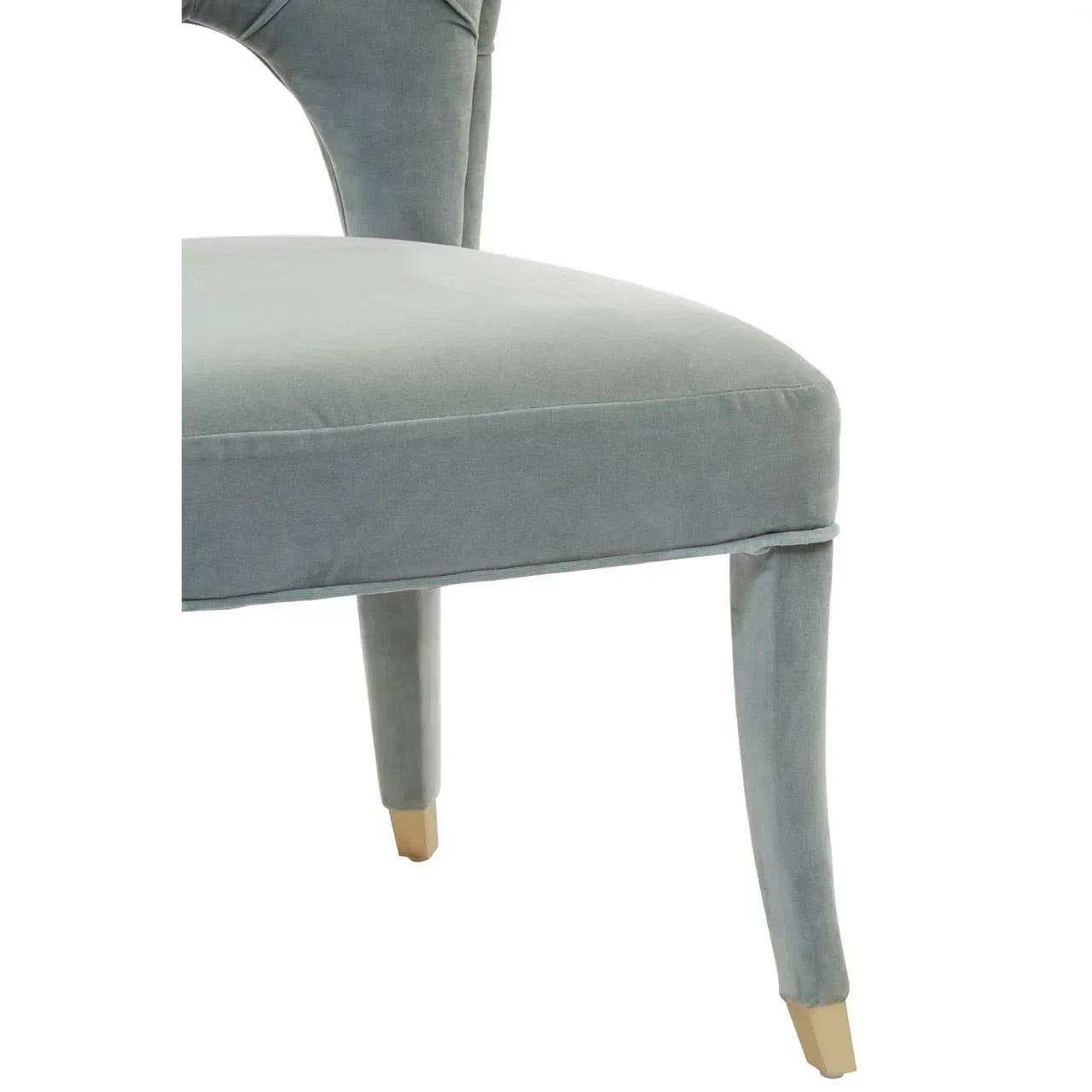Grey velvet dining chair with gold metal capped legs, partial side view