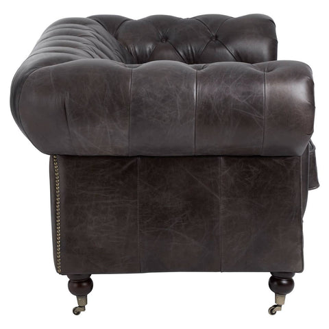 Dark grey brown leather Chesterfield 2 seat sofa featuring a tufted backrest and rolled arms, supported by wooden legs with casters for mobility. The upholstery has a rich texture, highlighting the classic design elements of the sofa