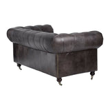 Chesterfield 2 seat sofa upholstered in dark grey-brown leather, featuring a tufted backrest and rolled arms. The sofa rests on four metal caster wheels, providing mobility. The overall design showcases a classic, elegant style suitable for various interior decor