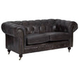 Dark grey-brown leather Chesterfield 2 seat sofa featuring a tufted backrest, rolled arms, and wooden legs with casters. The sofa has a classic design with a polished finish, suitable for a stylish living room setting