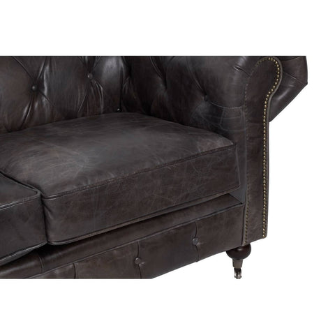Dark grey brown leather Chesterfield 2 seat sofa featuring tufted upholstery, rolled arms, and wooden legs. The close-up view highlights the texture of the leather and the plush cushions