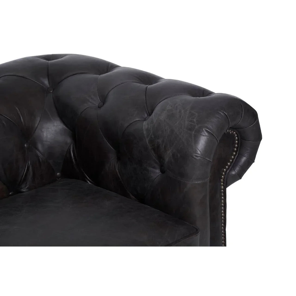 Dark leather sofa armrest with tufted back and nailhead trim detail