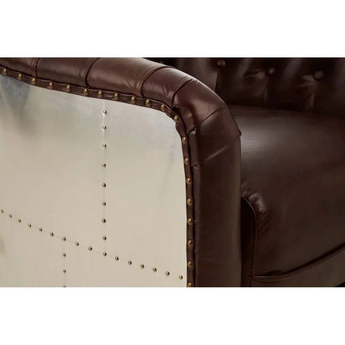 Brown leather sofa with metal side panel and decorative brass studs close-up