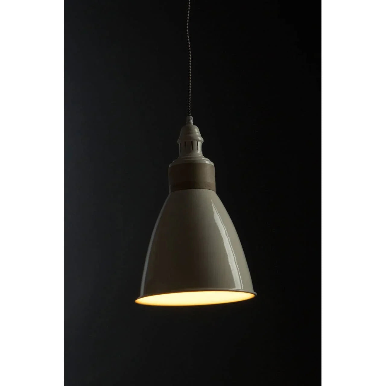 Cream pendant ceiling light with glossy finish and warm glow against black background