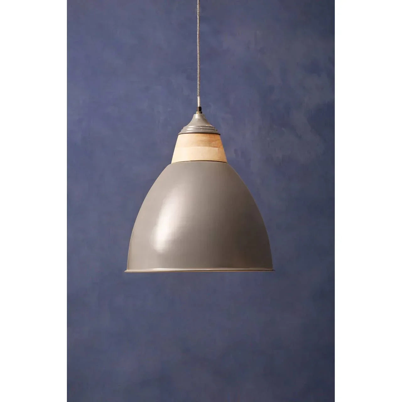 Grey metal pendant light with wooden accent against blue wall, modern ceiling lighting