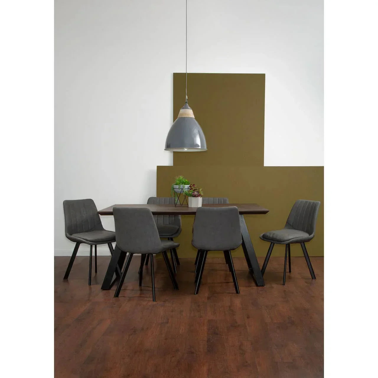 Modern dining table set with six grey fabric chairs on wooden floor under pendant light