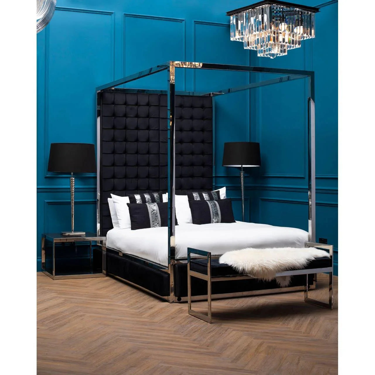 Black velvet four poster bed with chrome frame in modern blue bedroom with matching bench