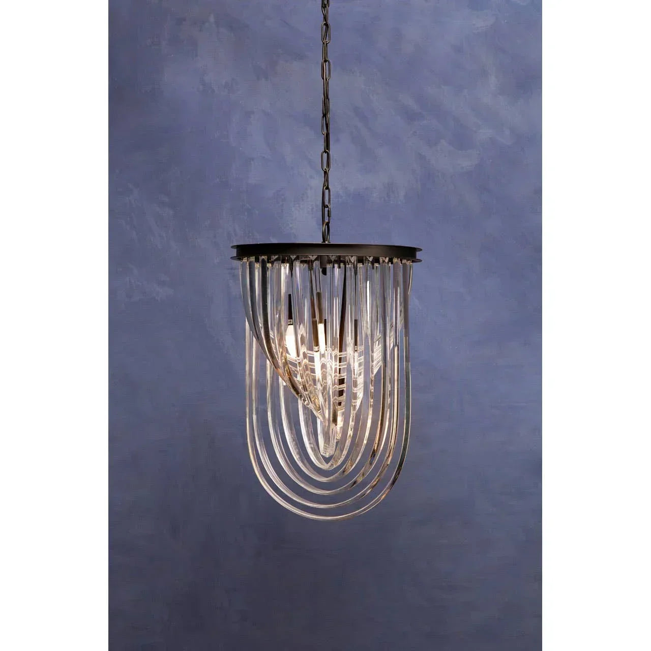 Modern glass pendant ceiling light with metal frame against a textured blue wall