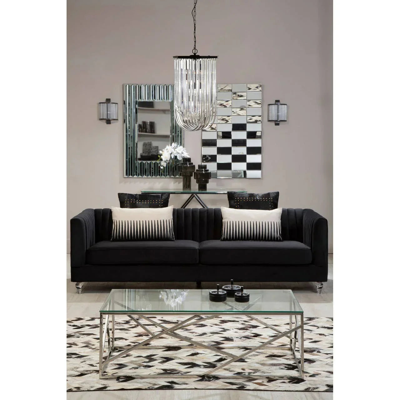 Black velvet sofa with striped cushions, glass coffee table, and geometric rug in modern living room