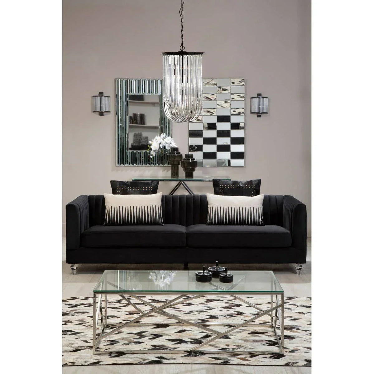 Black velvet sofa with striped cushions, glass coffee table, and geometric rug in modern living room