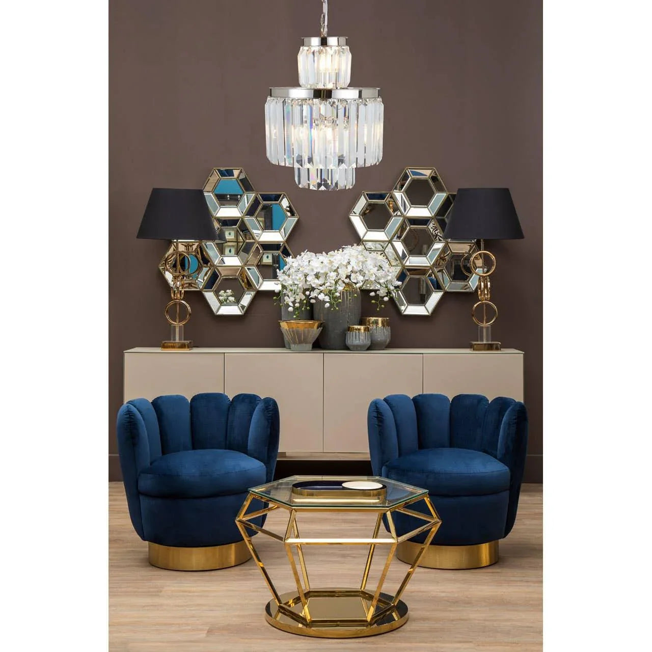 Blue velvet accent chairs with gold base, geometric gold coffee table, hexagonal mirrors