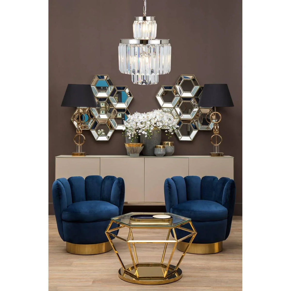 Blue velvet accent chairs with gold base, geometric gold coffee table, hexagonal mirrors