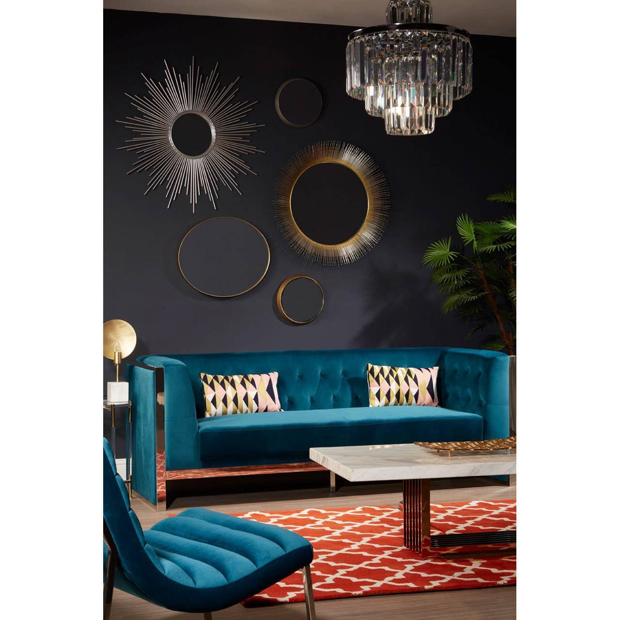 Teal velvet sofa with geometric cushions in modern living room, marble coffee table, wall mirrors