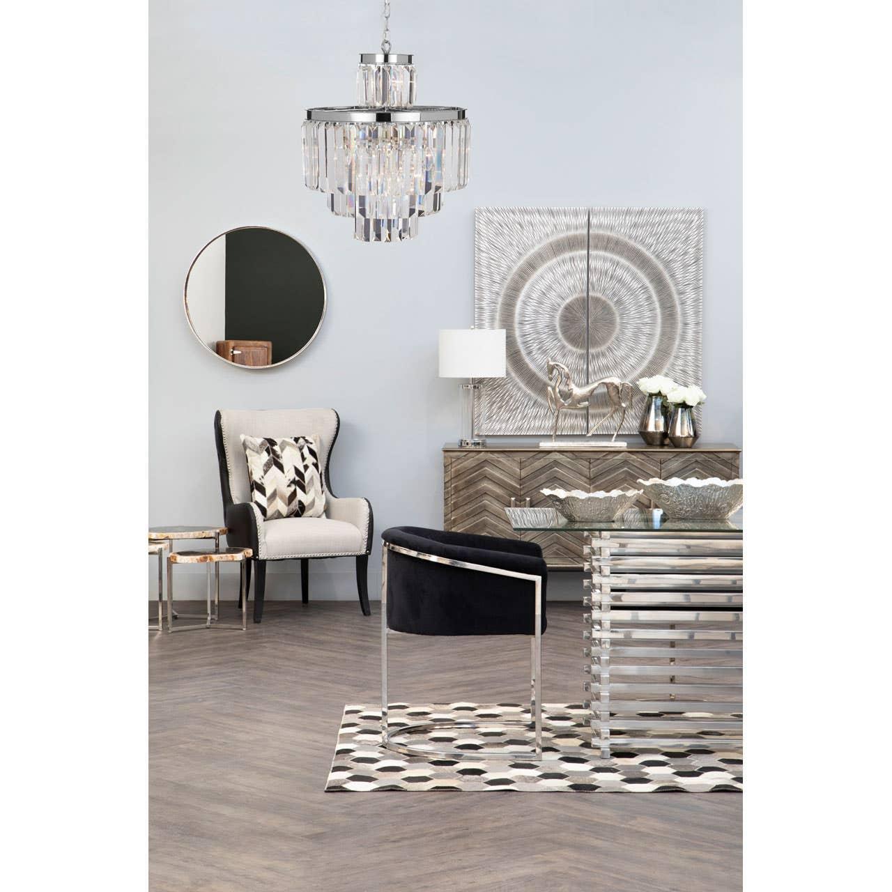Modern living room with velvet accent chair, glass table, chandelier, and wooden sideboard
