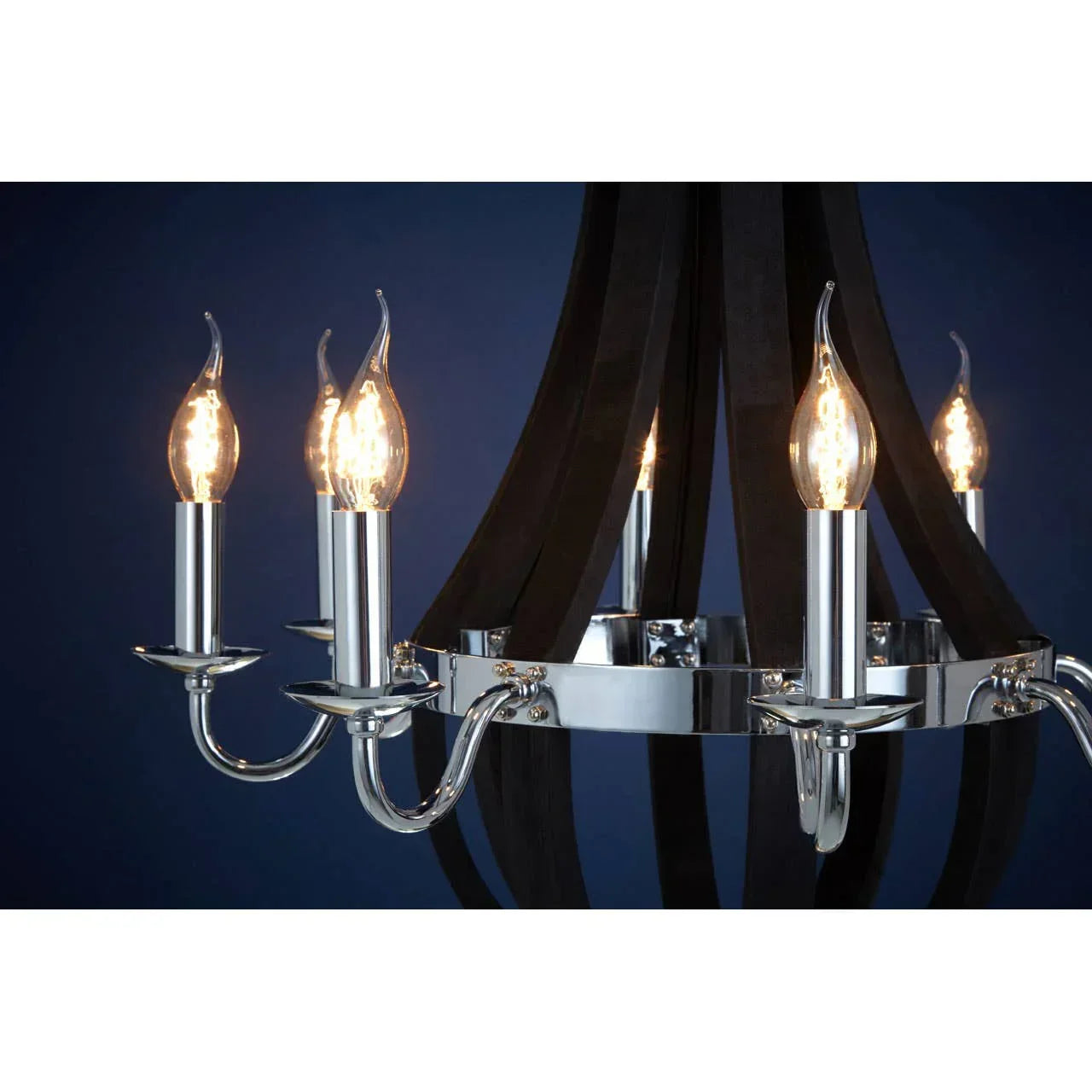 Chrome chandelier with candle-style bulbs and curved arms against a dark blue background