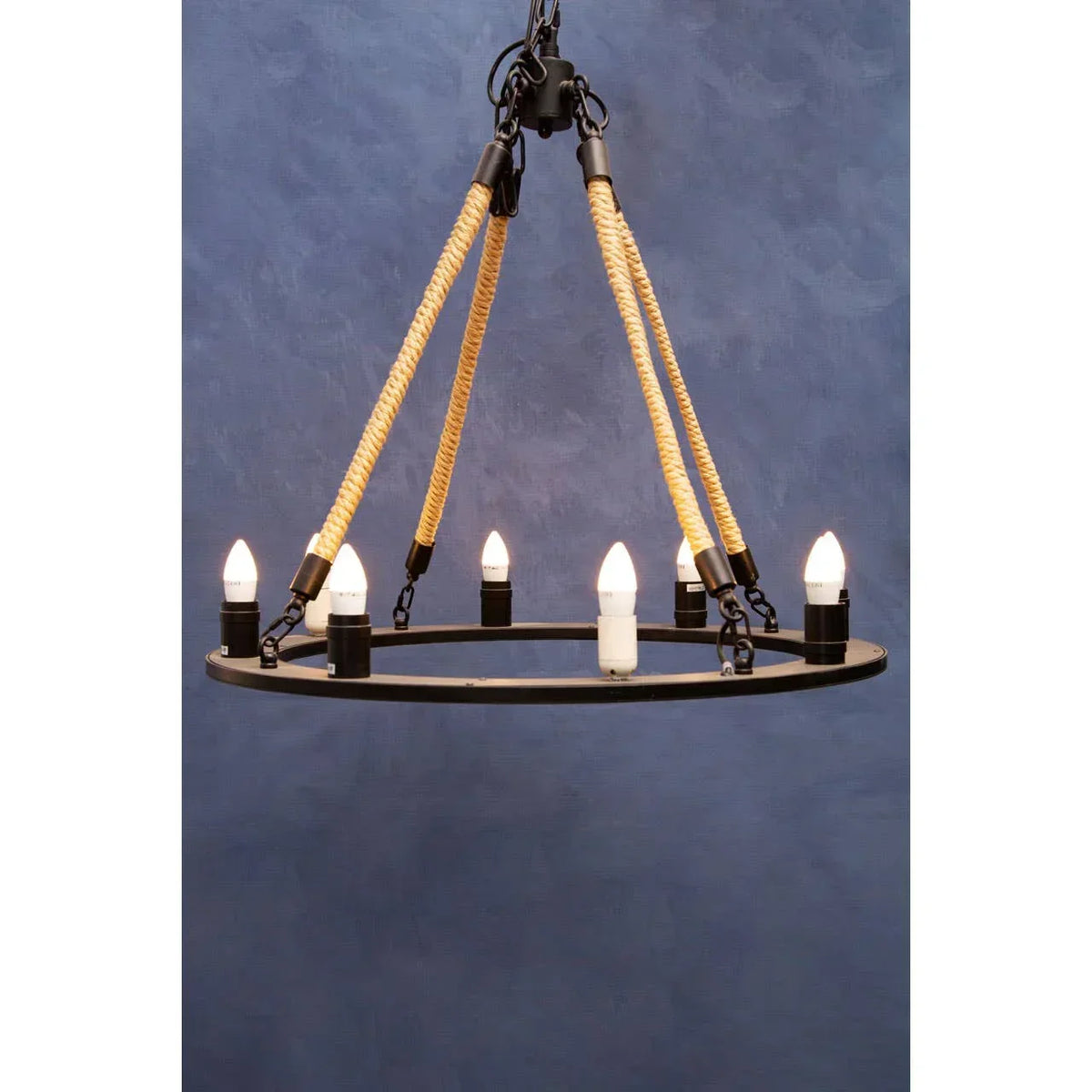Round rope chandelier with black metal frame and six exposed bulbs against blue background